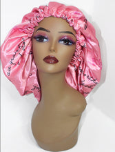 Load image into Gallery viewer, Light Pink Satin Bonnet. Contains Self-Affirmations written in slight cursive black writing. Self-Affirmations say things like &quot;Anything is possible&quot; &quot;My failures are a part of my journey to success&quot; &quot;I am enough&quot; &quot;I am royal&quot; etc.